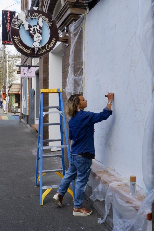 Morgan Zion paints her three-panel mural on the front of a boarded-up Molly Moon's