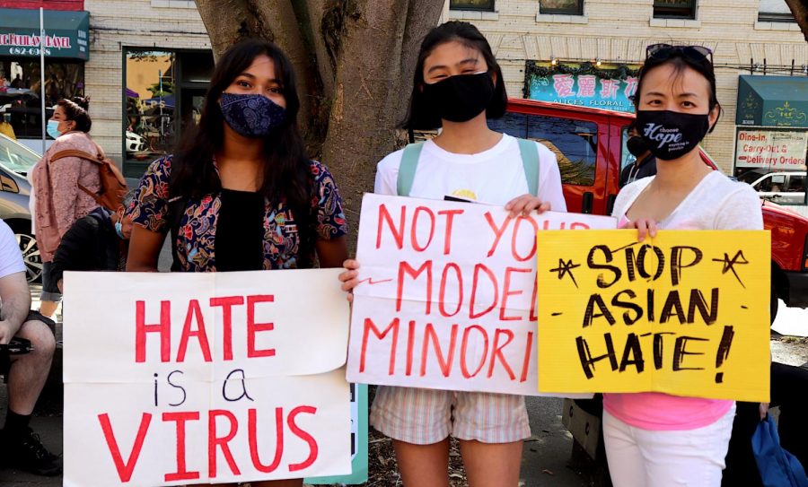 Protestors prepare signs at Hing Hay Park in the hot Saturday sun.