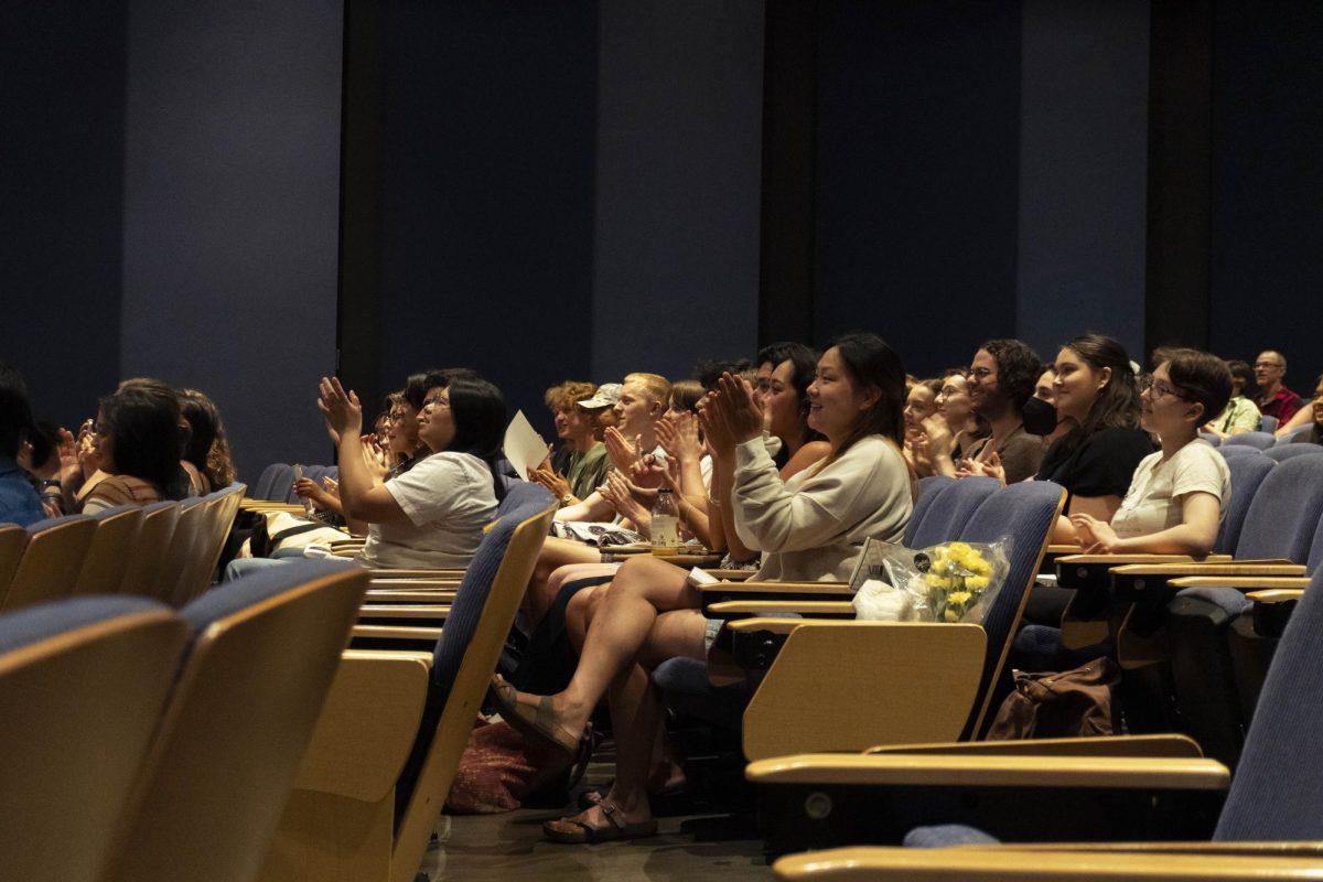 Audience members applaud the filmmakers.